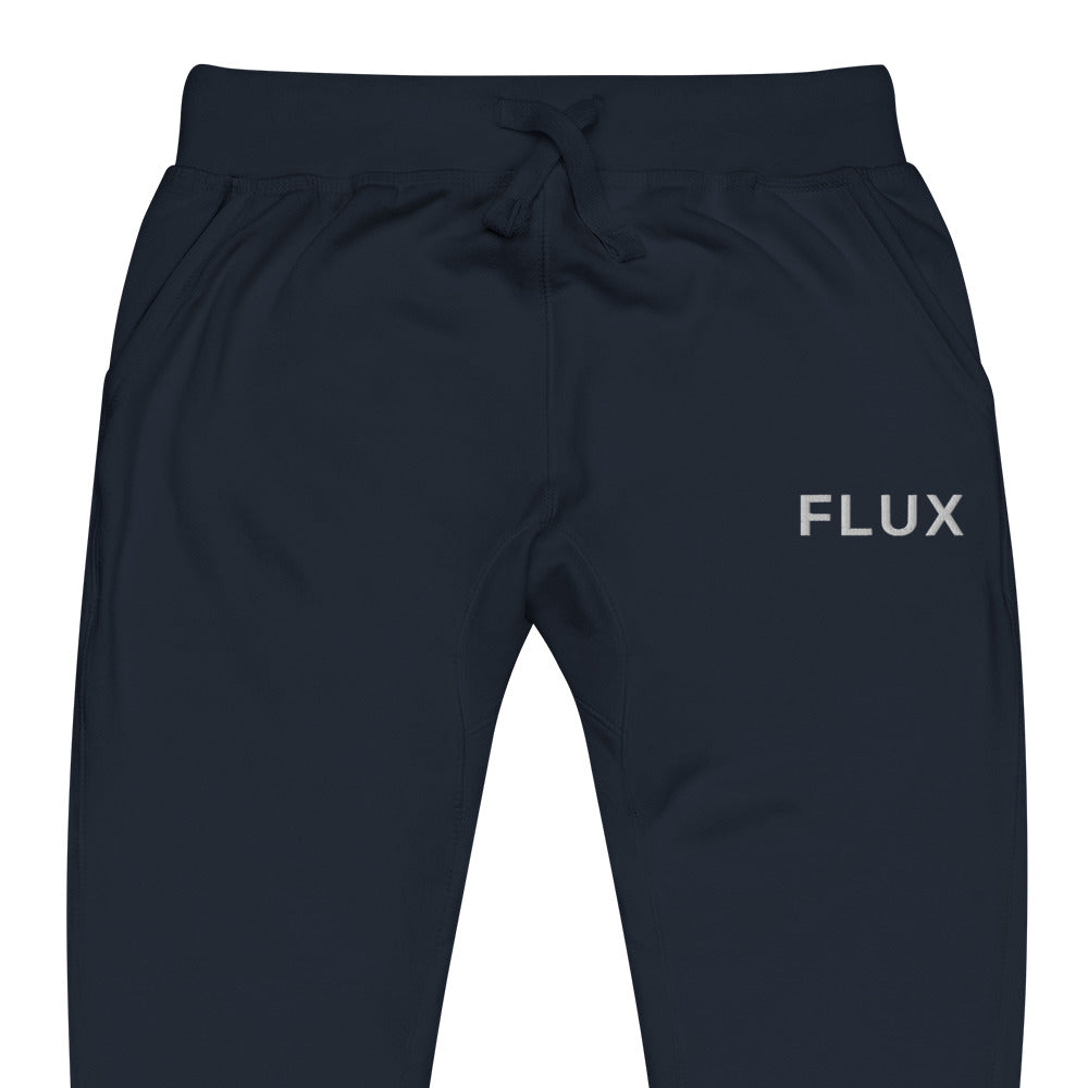 Close-up of the FLX HOME Blue Side Fleeced Jogger in Navy Blazer fleece, showing the white FLUX wordmark embroidered at the wearer-left hip.